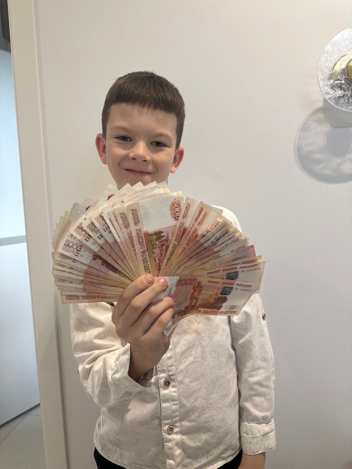 Boy displays cash, dog rides passenger seat in Прикамский