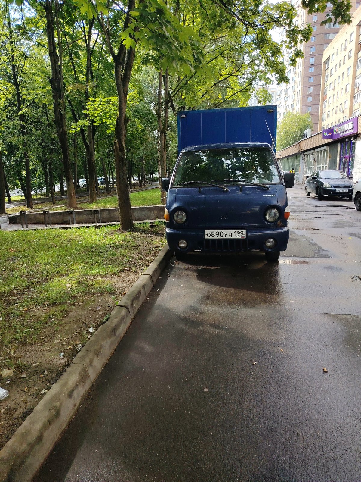 Wet streets and a local commercial strip in Dolgoprudny