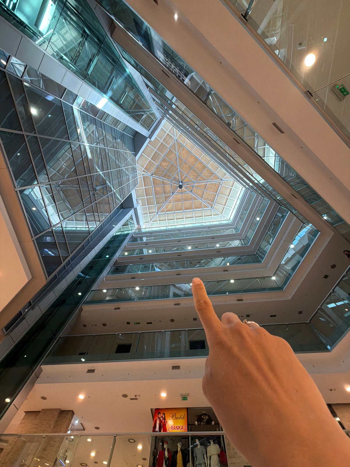 Woman takes selfies in glass atrium building in Budva