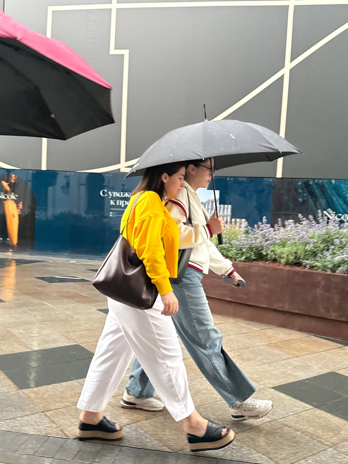 Pairs moving through a rainy Moscow pedestrian zone