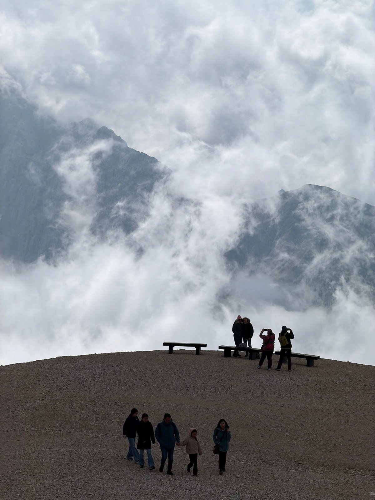 Group pauses on a cloud-wrapped alpine ridge in Wildermieming