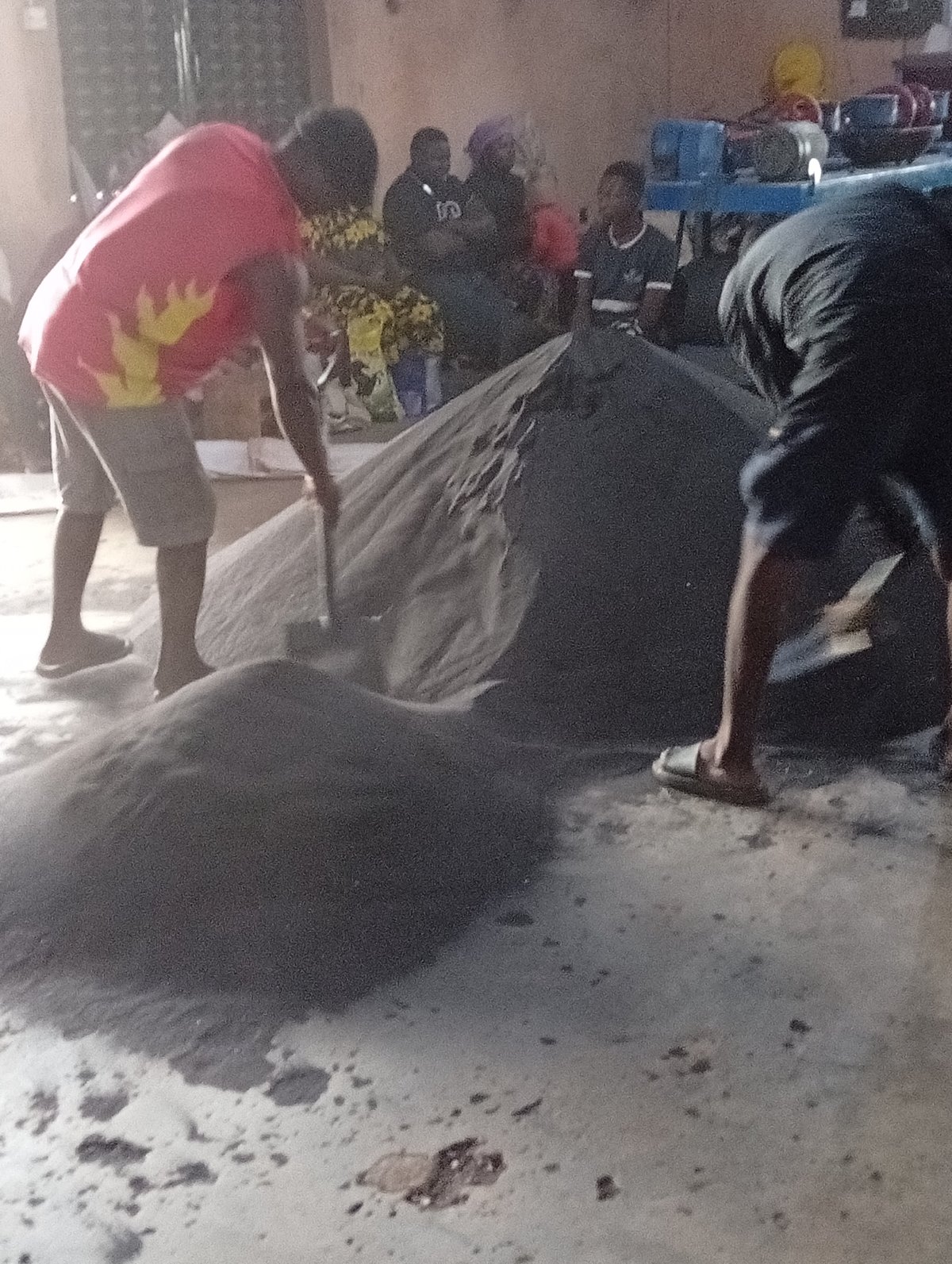Workers handle sand, materials in Gura Top warehouse operation