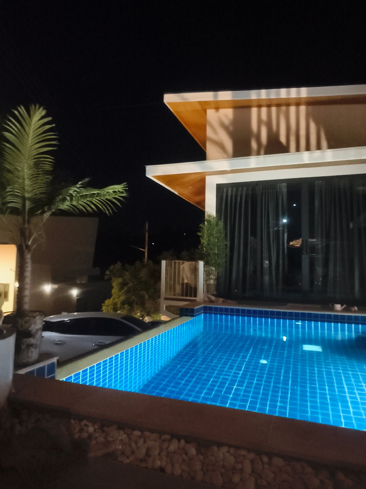 Nighttime resort pool glowing with underwater lights