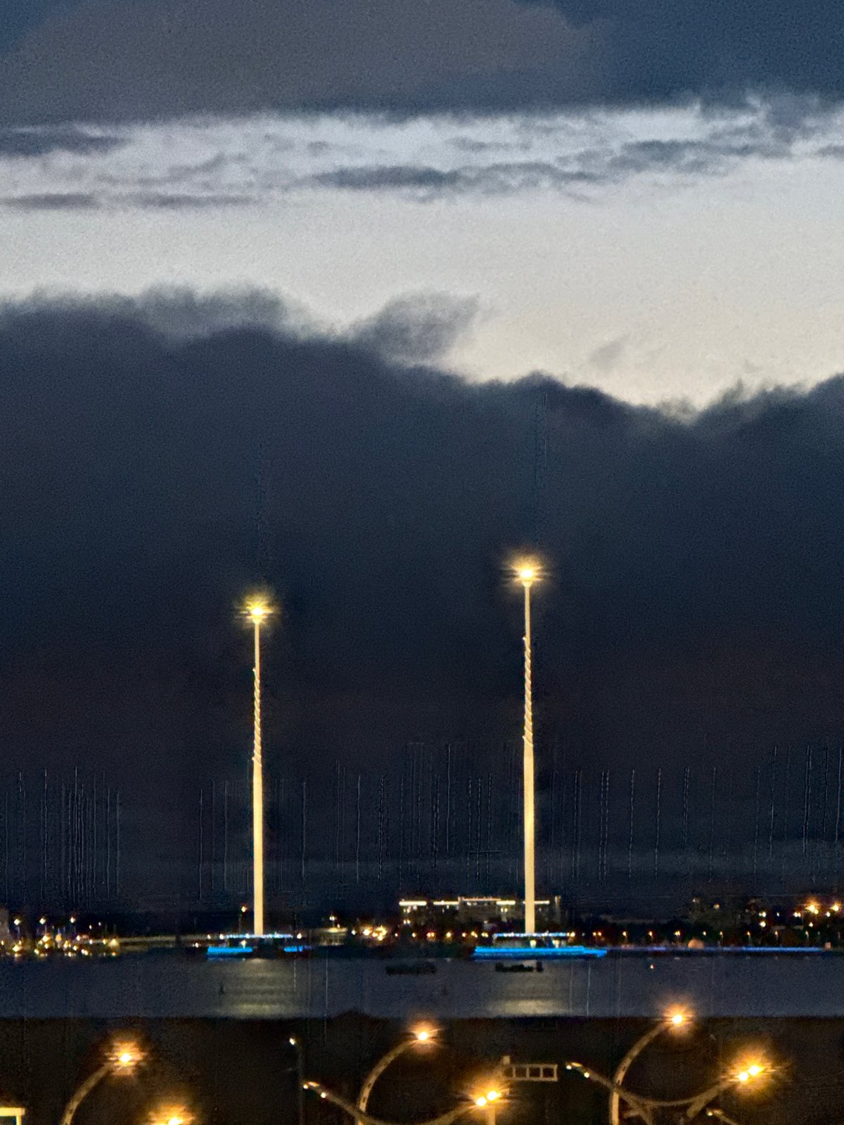 Lakhta Center and Gazprom Arena glow blue under stormy skies