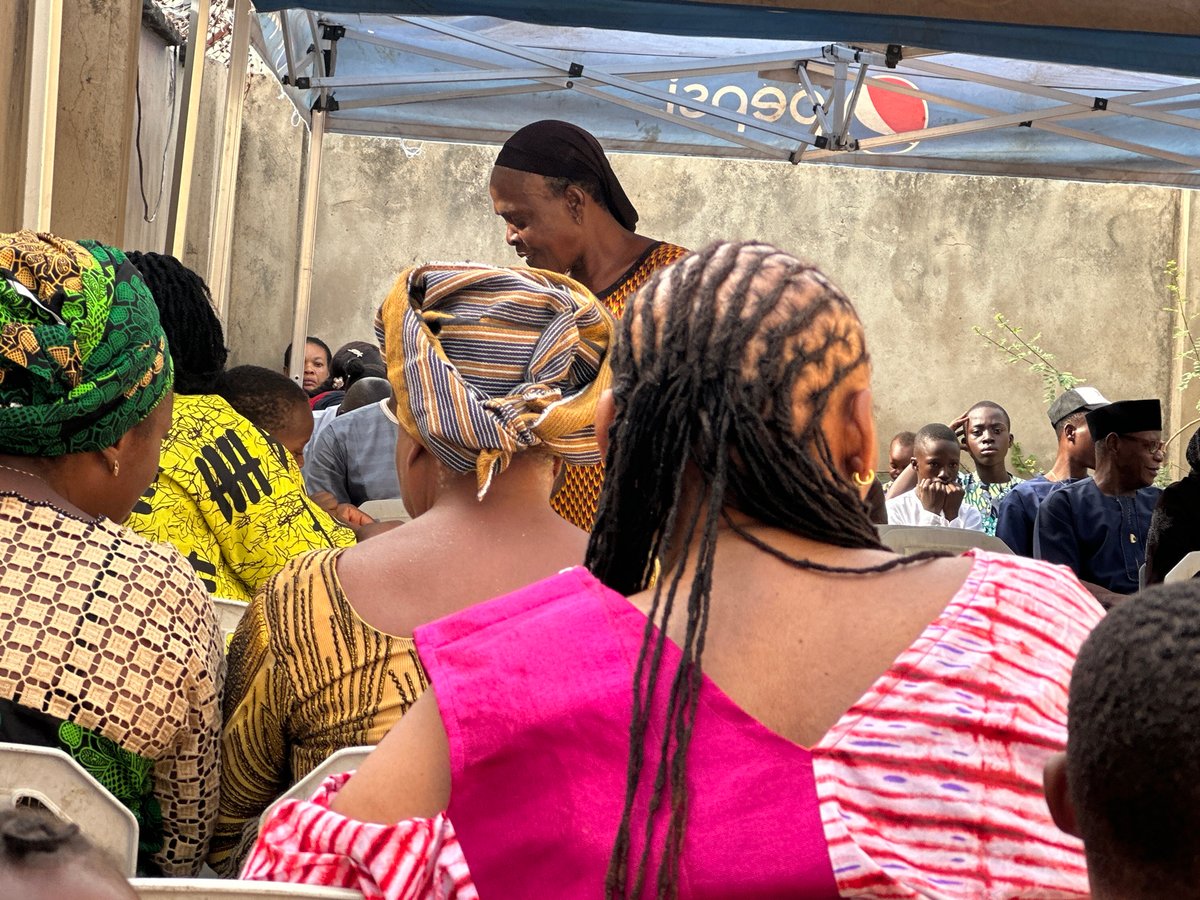 Community gathering under Pepsi canopy features traditional dress