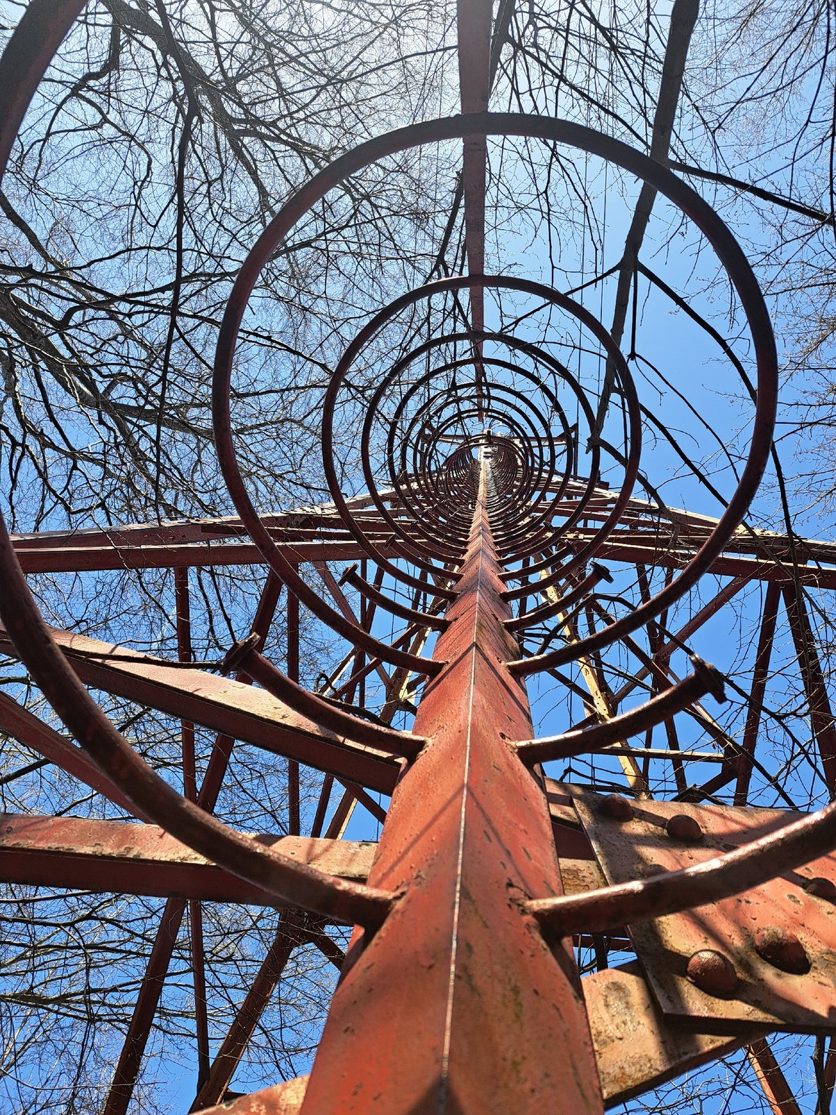 Rusty tower structure photographed against clear blue sky