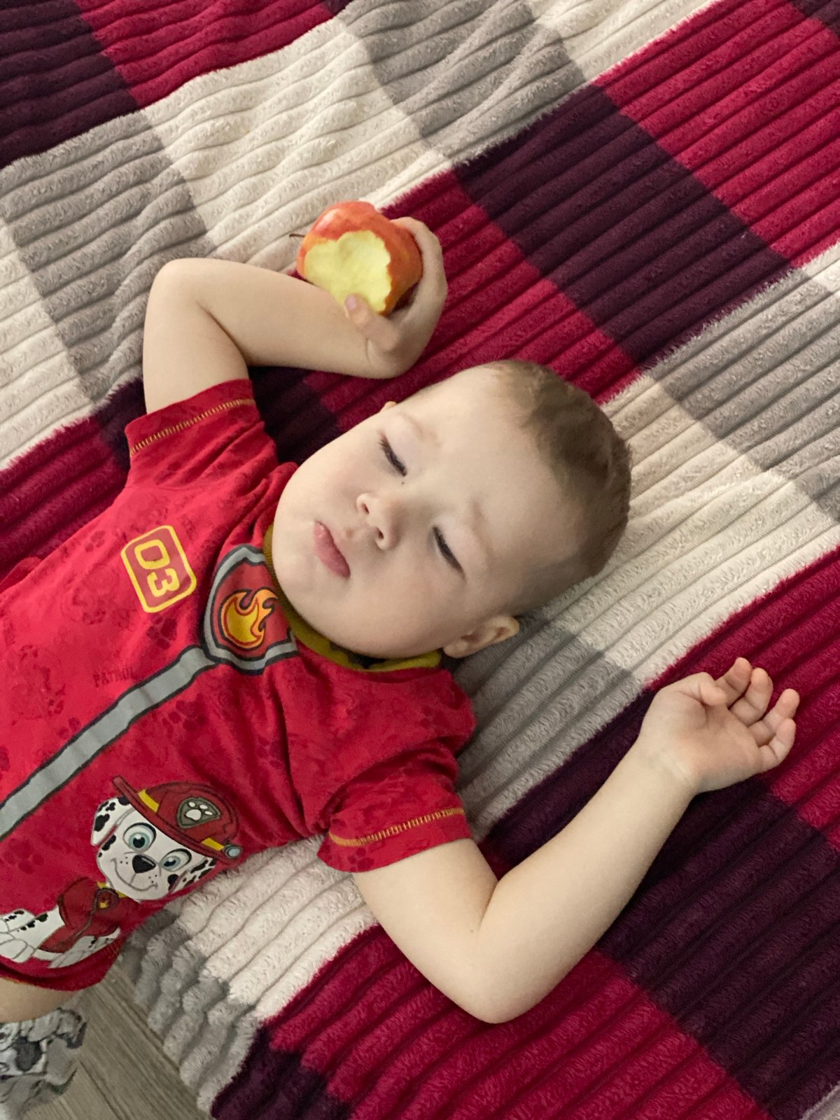 Child sleeps on checkered blanket in Sochi