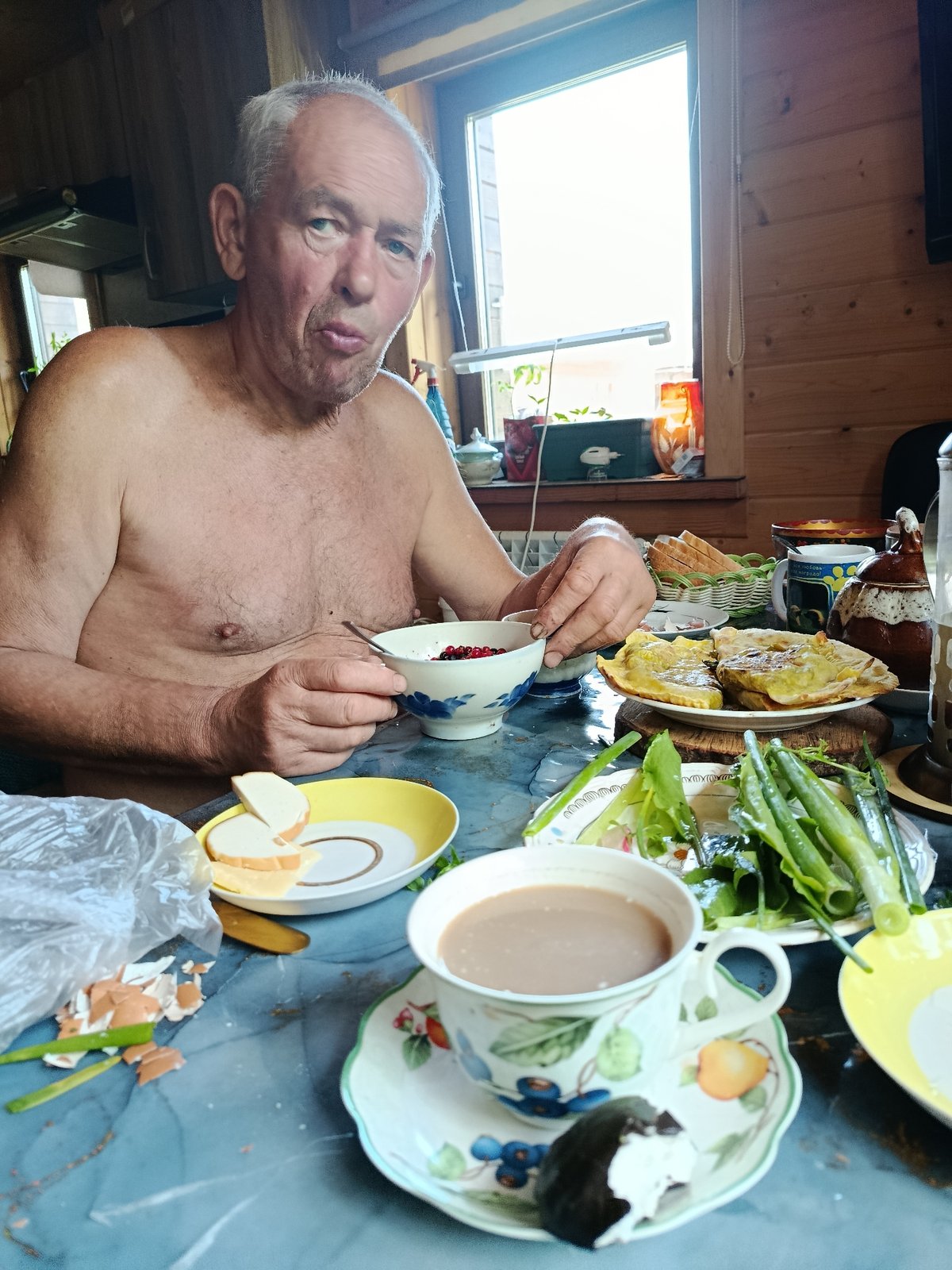 Elderly man enjoys traditional meal with berries and flatbreads