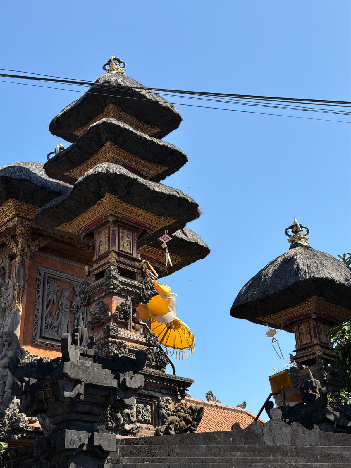 Ornate multi-tiered Balinese temple against a clear blue sky