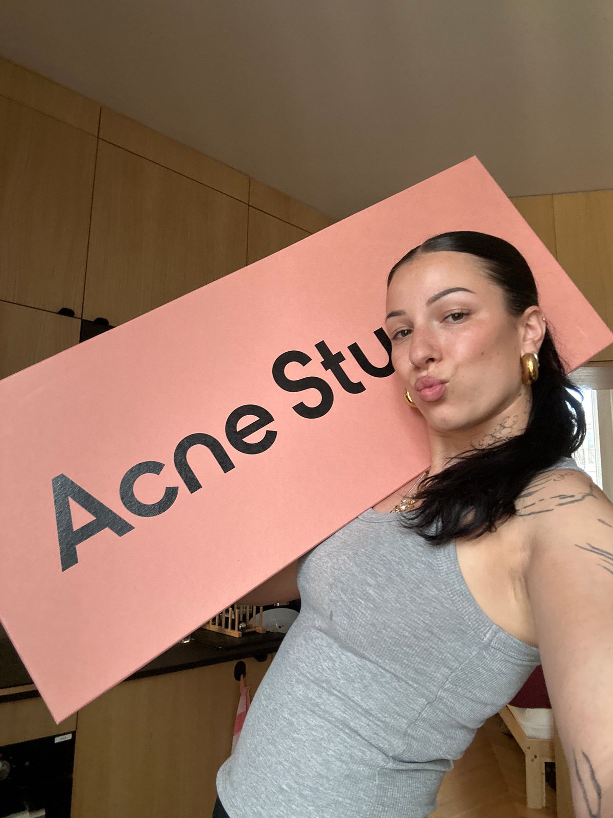 Woman poses with Acne Studios box in Saint-Ouen