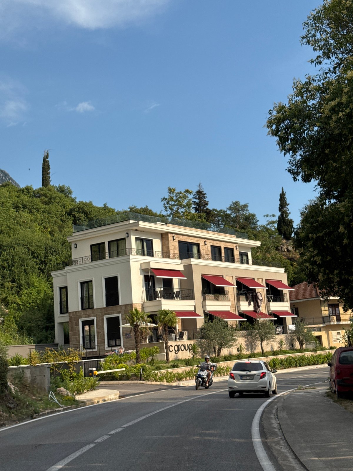 White hillside building with red awnings in Dobrota, Montenegro