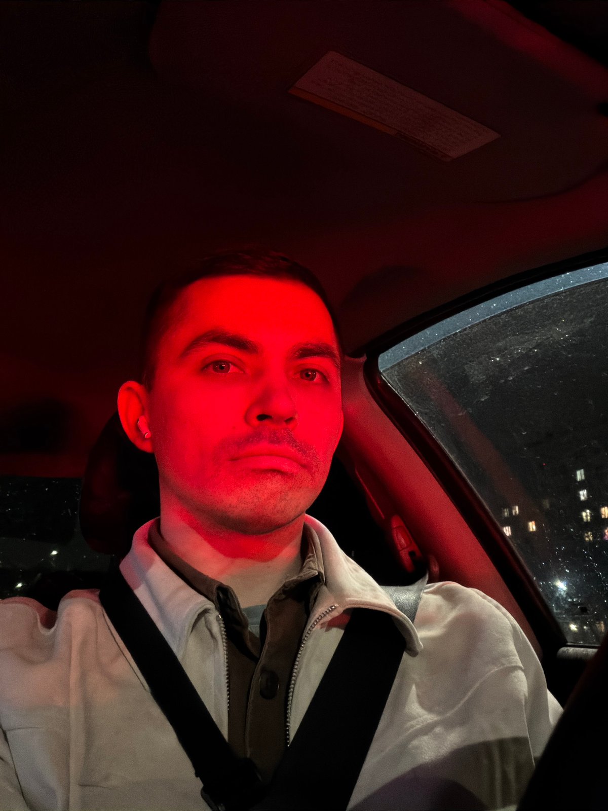 Man observed in car interior illuminated by red light