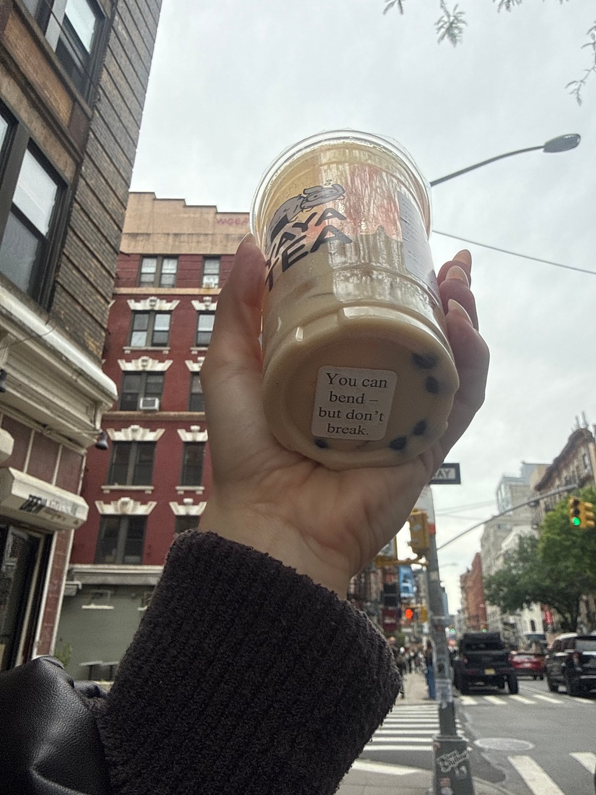 Person holds inspirational bubble tea cup on NYC street