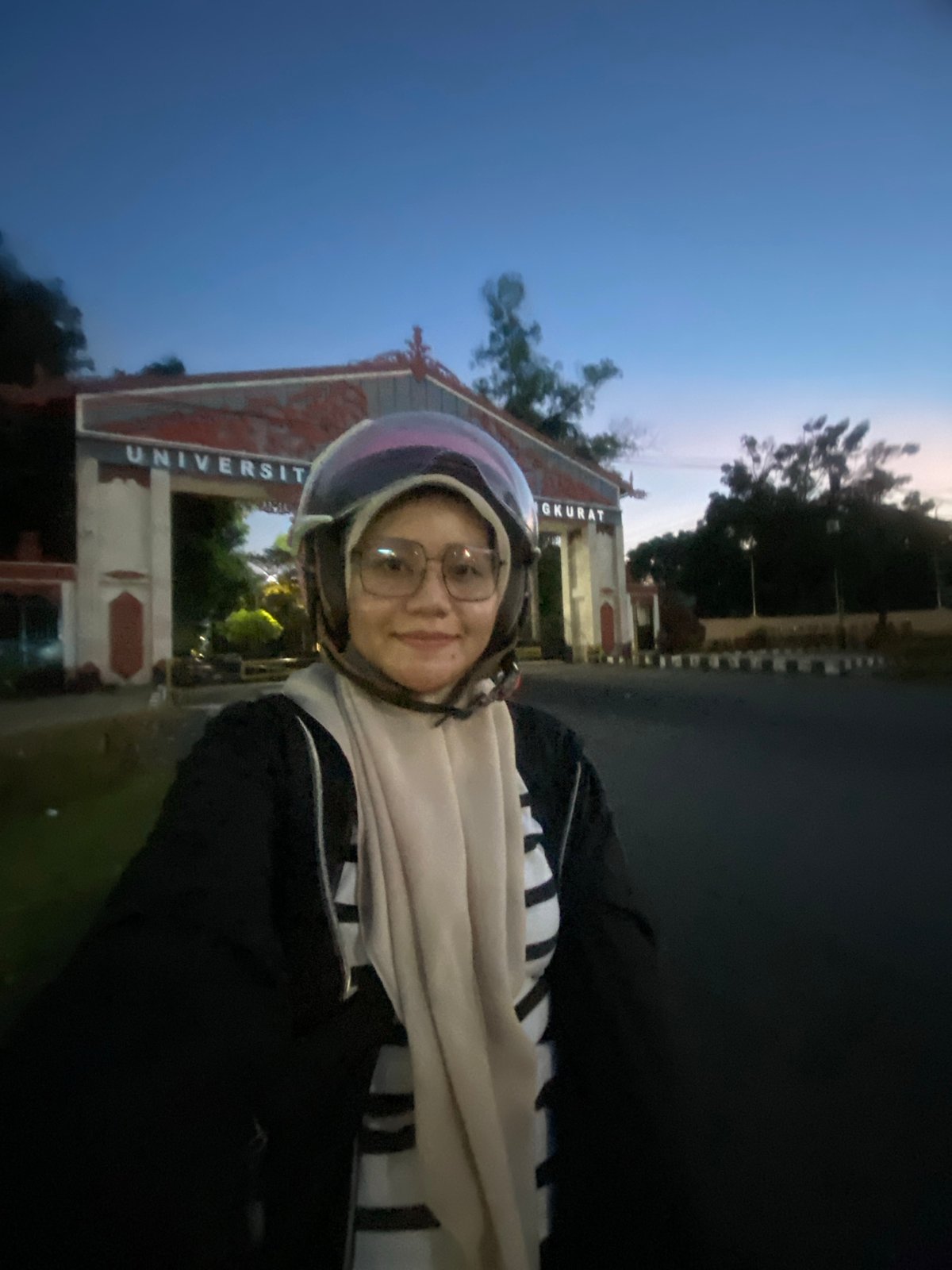 Dusk ride through Banjarbaru's lit landmarks and university gate