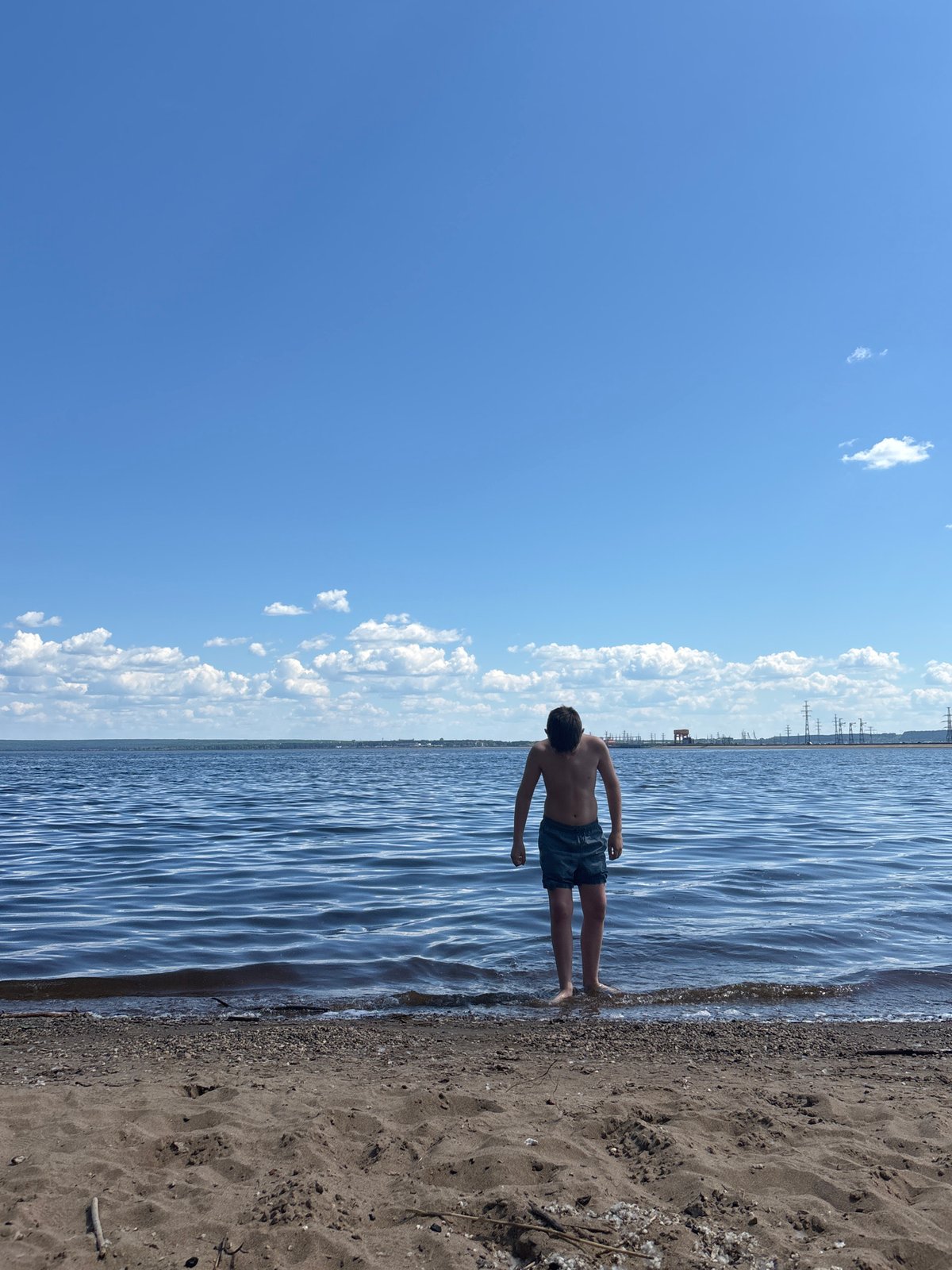 Young man contemplates calm water in Chaikovsky, Russia