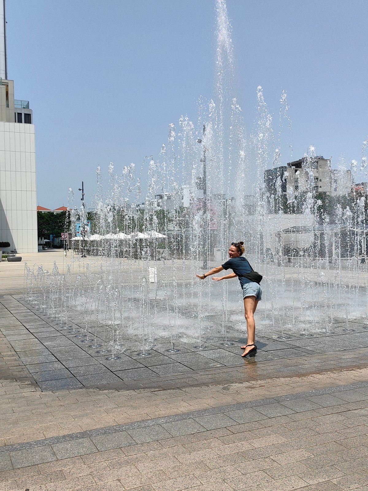 Woman plays at fountain in Hanoi public square