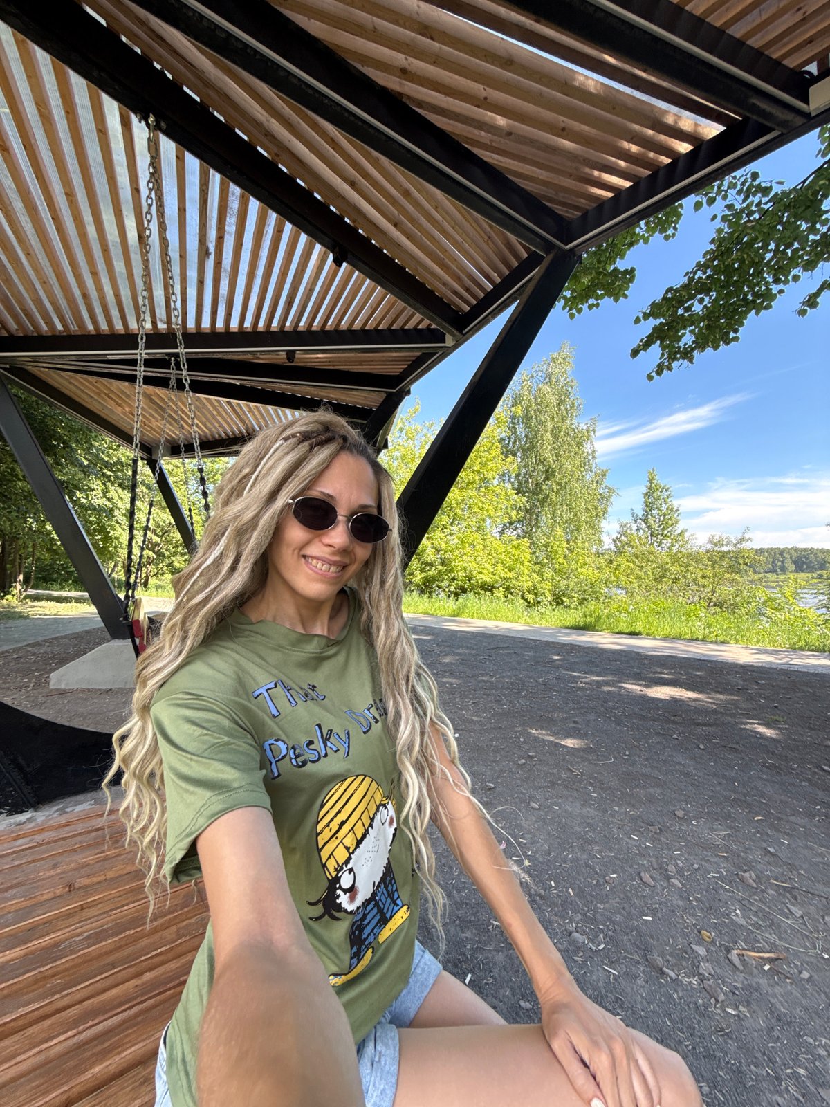 Woman in green shirt smiles on bench