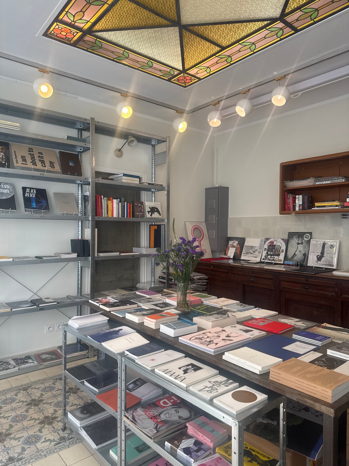 Parisian bookstore interior documented with books and purple flowers