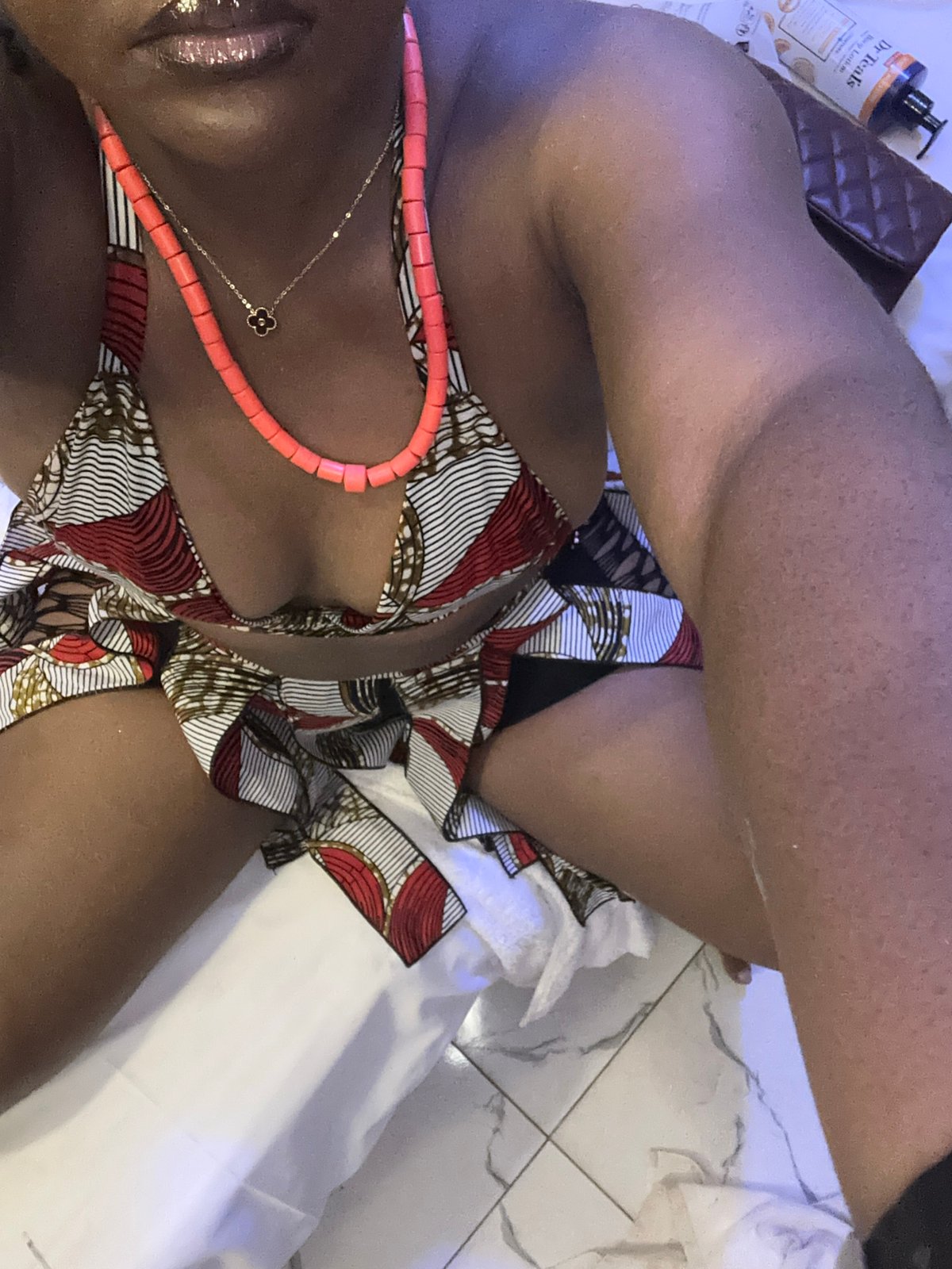 Patterned bikini and coral necklaces, indoors in Nyanya