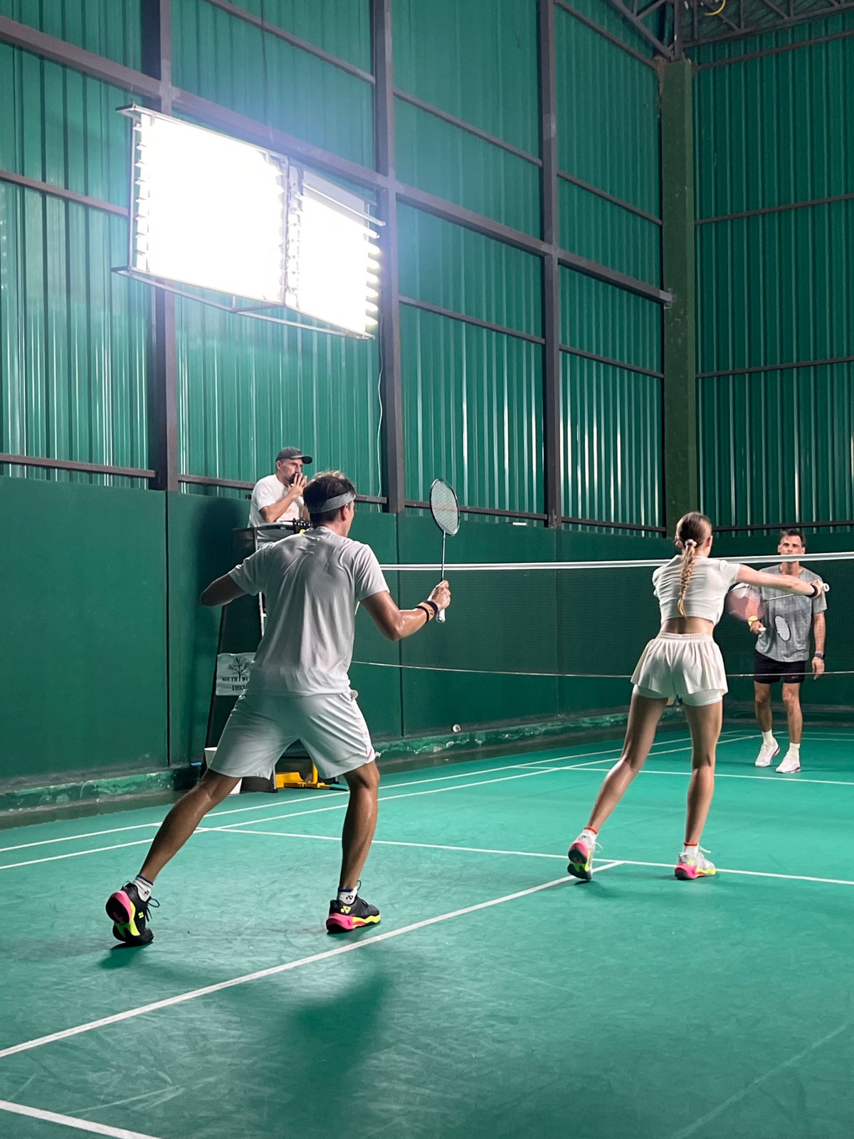 Indoor doubles badminton match captured by multiple witnesses