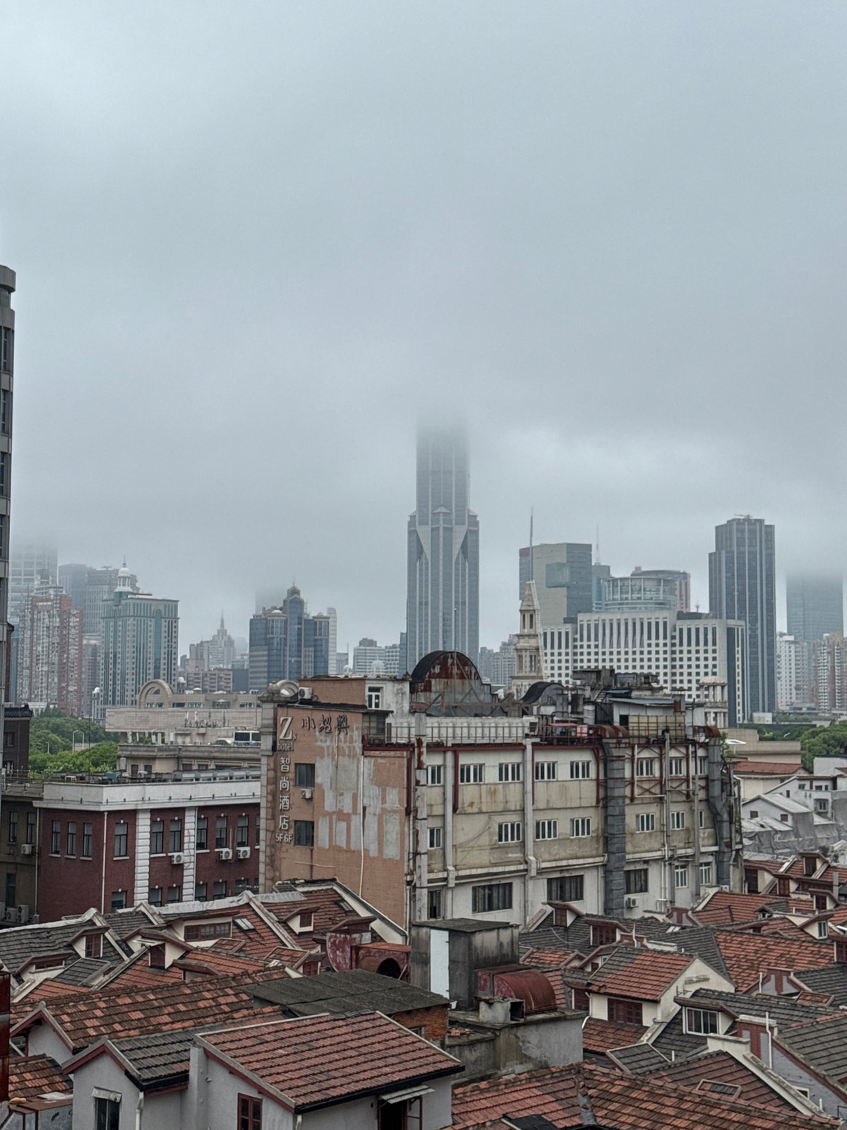 Woman on Shanghai balcony amid traditional and modern cityscape