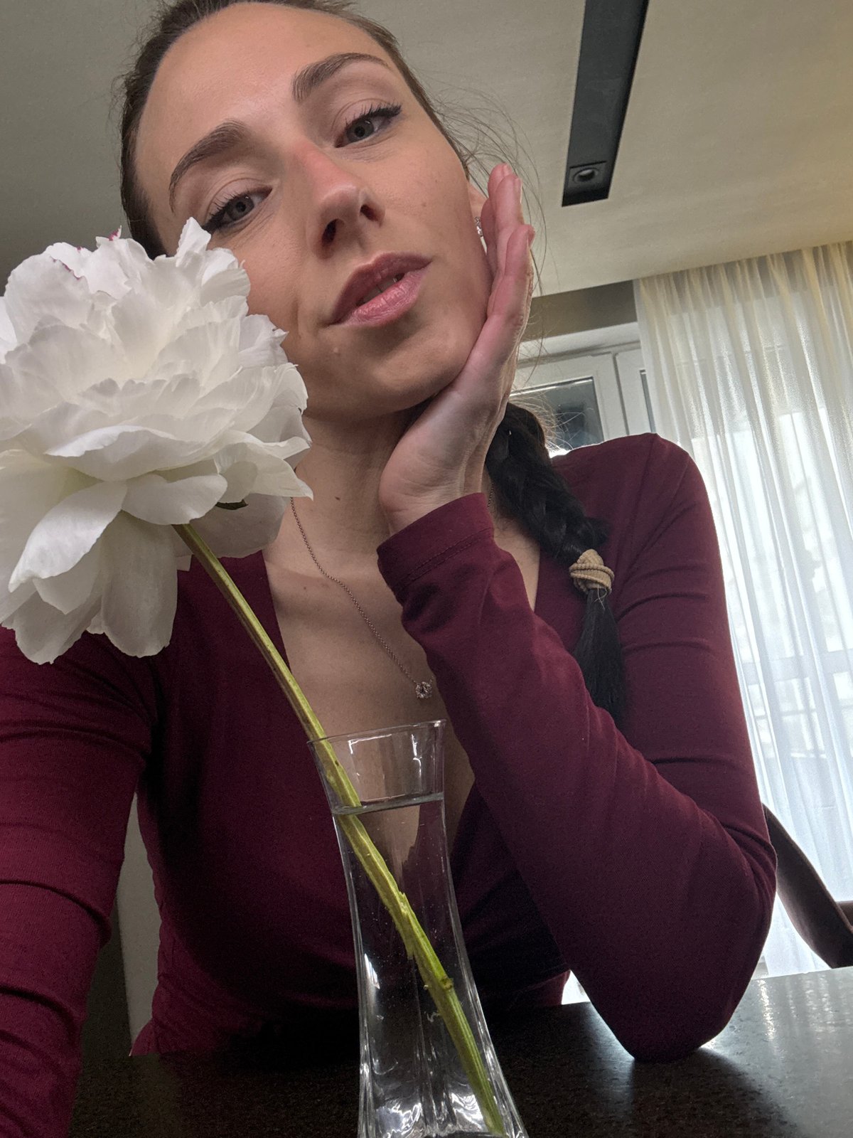 Woman poses with flower near wine display in Saint Petersburg