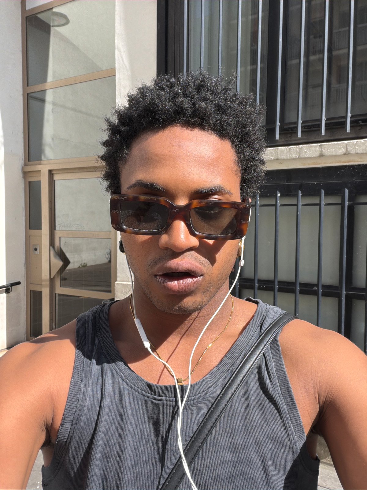 Man walks Paris street listening to music on sunny afternoon