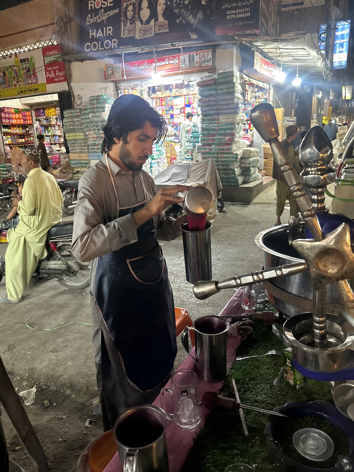Street vendor serves drinks amid crowded scene in Quetta