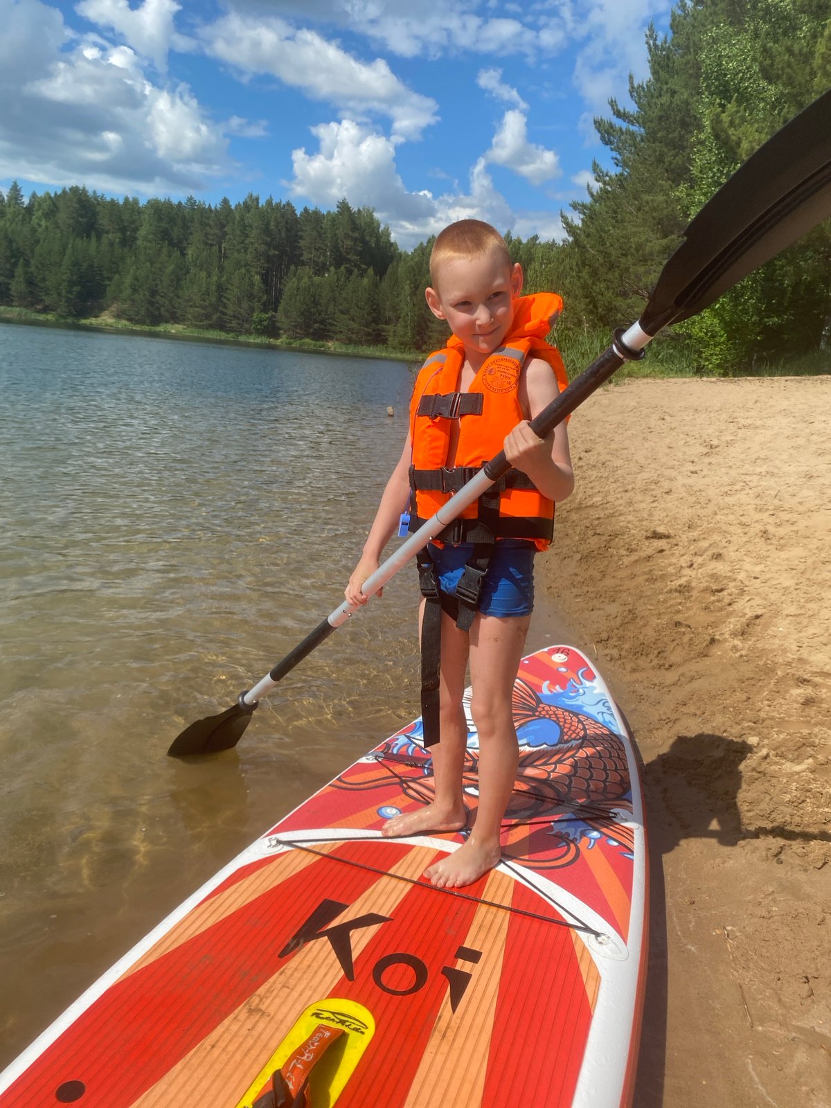 Family enjoys lake day with paddleboarding in Novyi, Russia