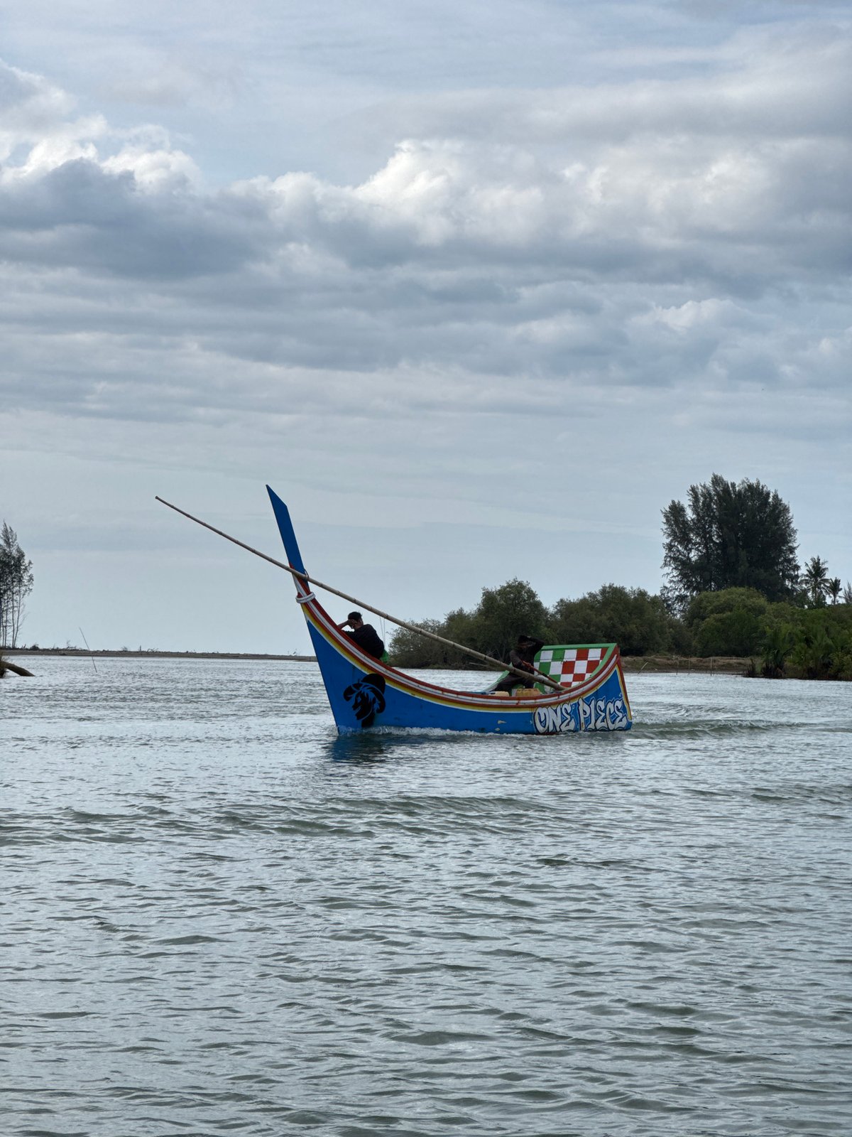 Colorful traditional longboats navigating a river in Rhieng Mancang