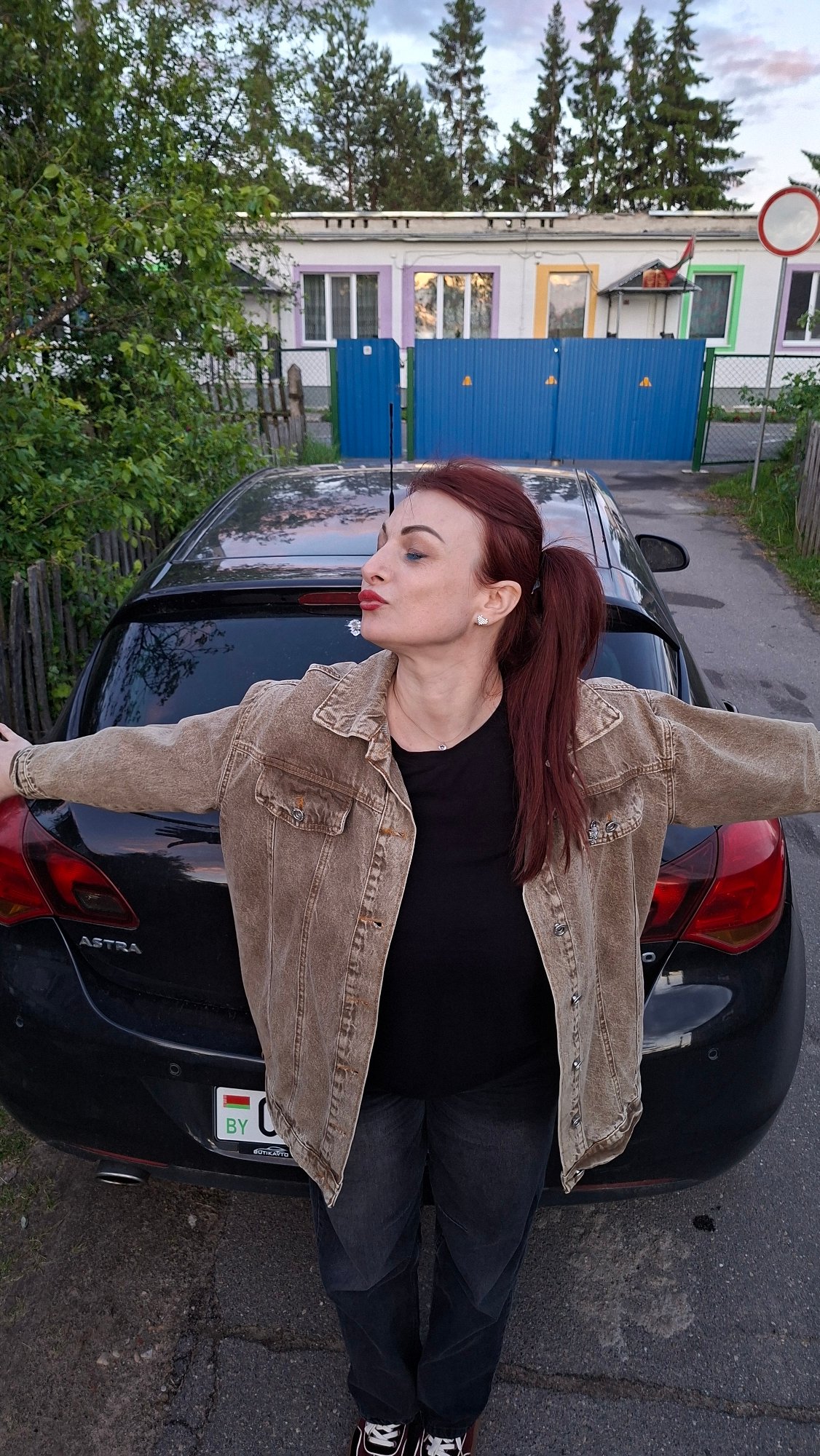 Woman lies on car hood during twilight in Belarus