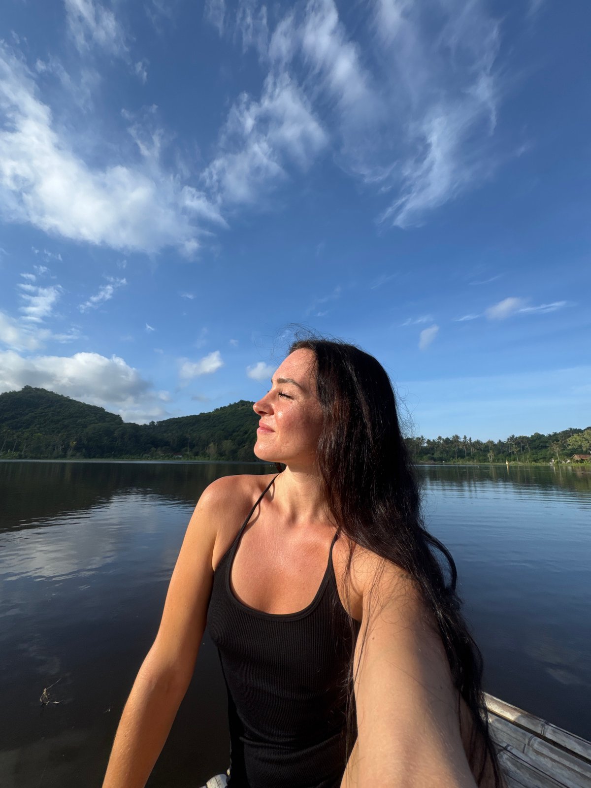 Woman takes selfies on bamboo raft at Indonesian lake