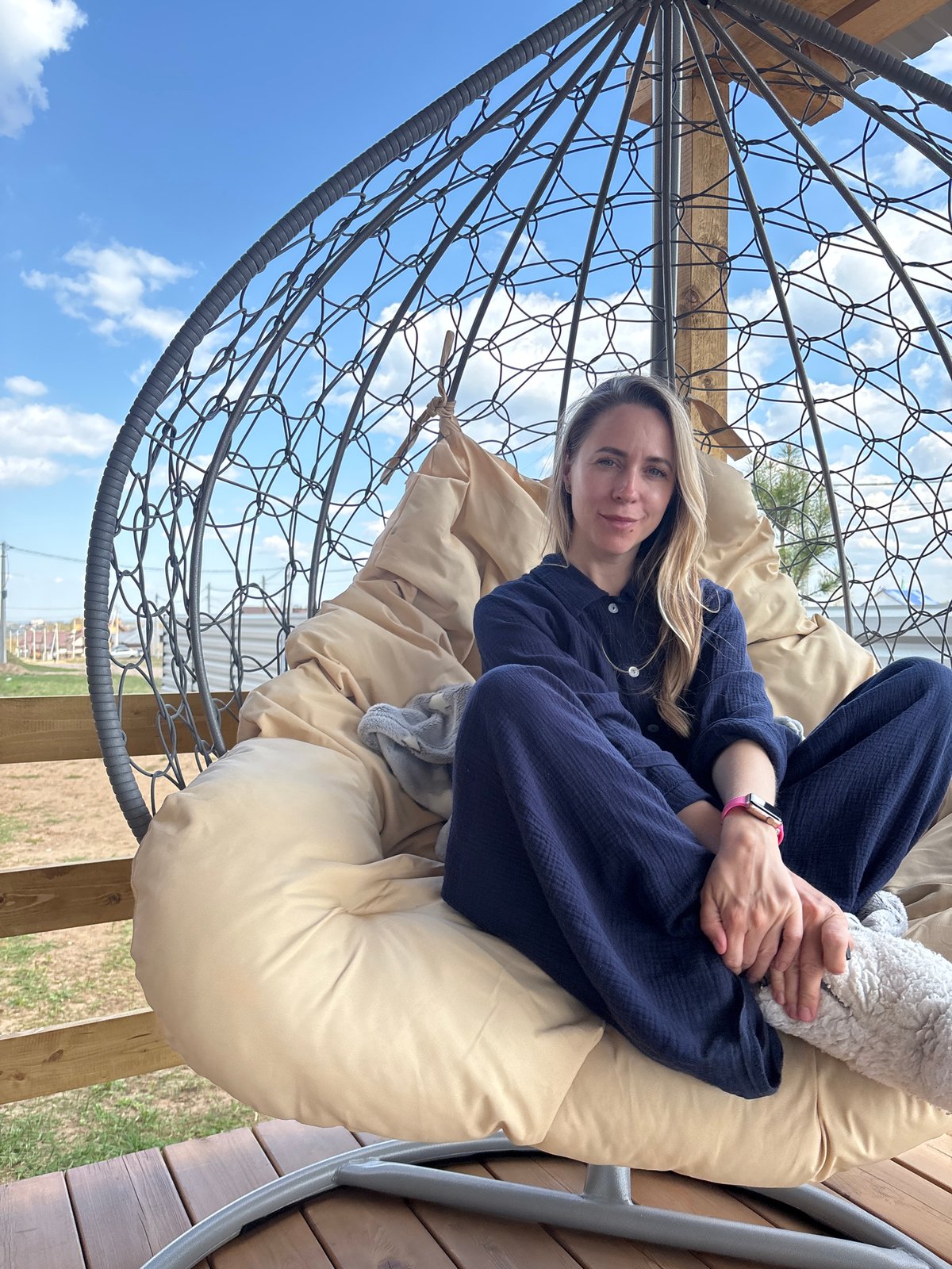 Woman relaxes in hanging chair, poses with roses in Chaikovsky