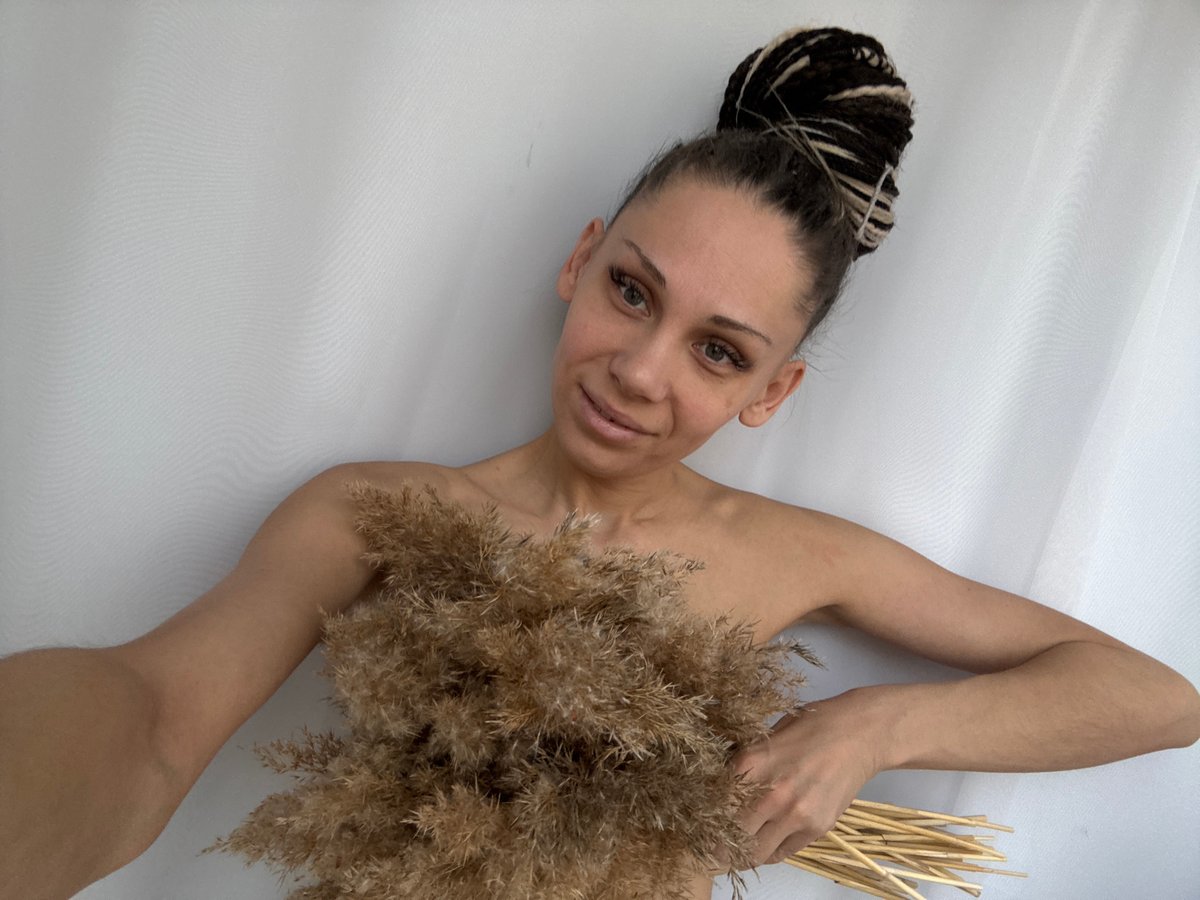 Woman poses with dried grass in artistic photo session