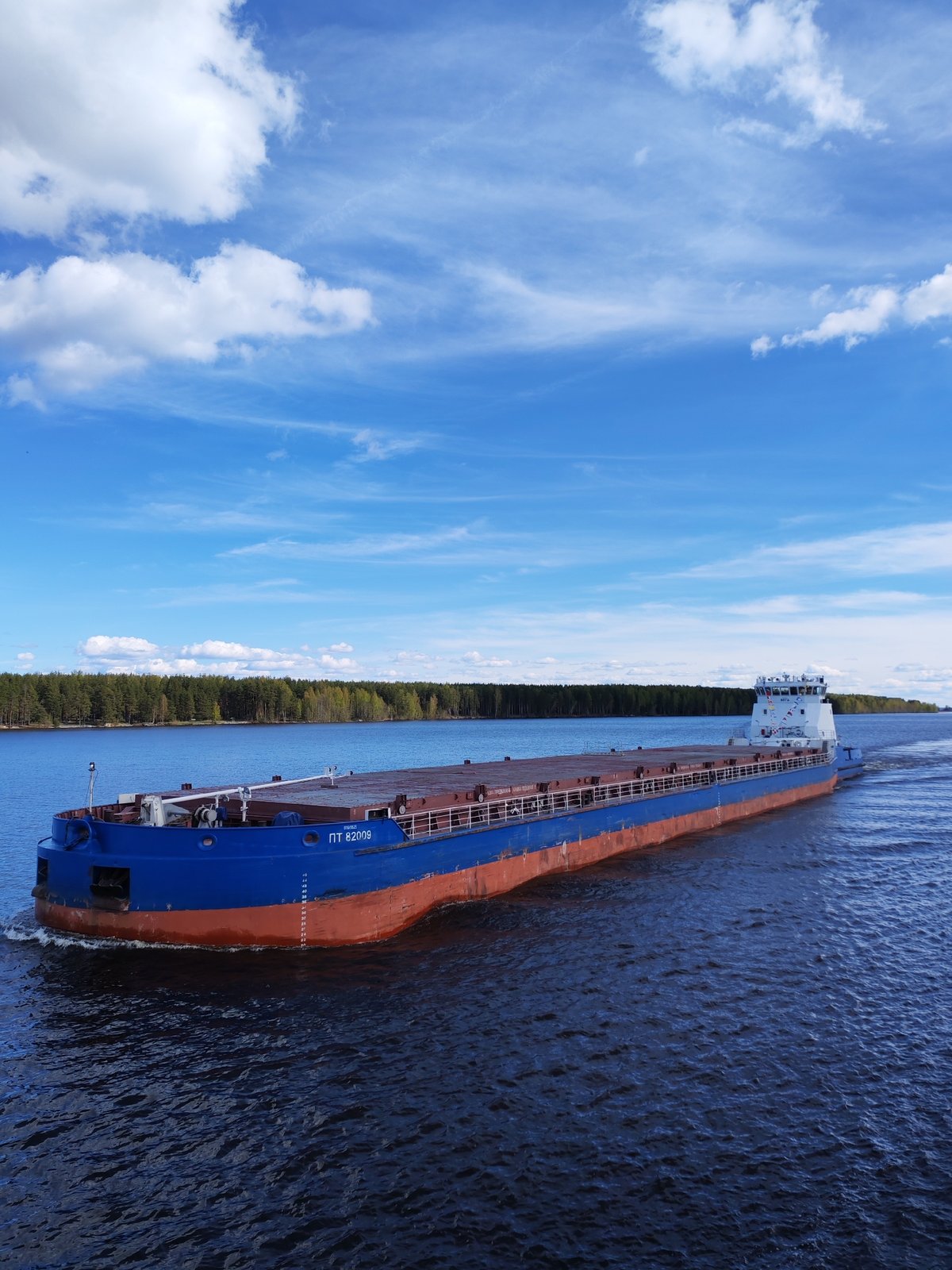 Tugboat tows cargo barge through Russian waterway near Topornya