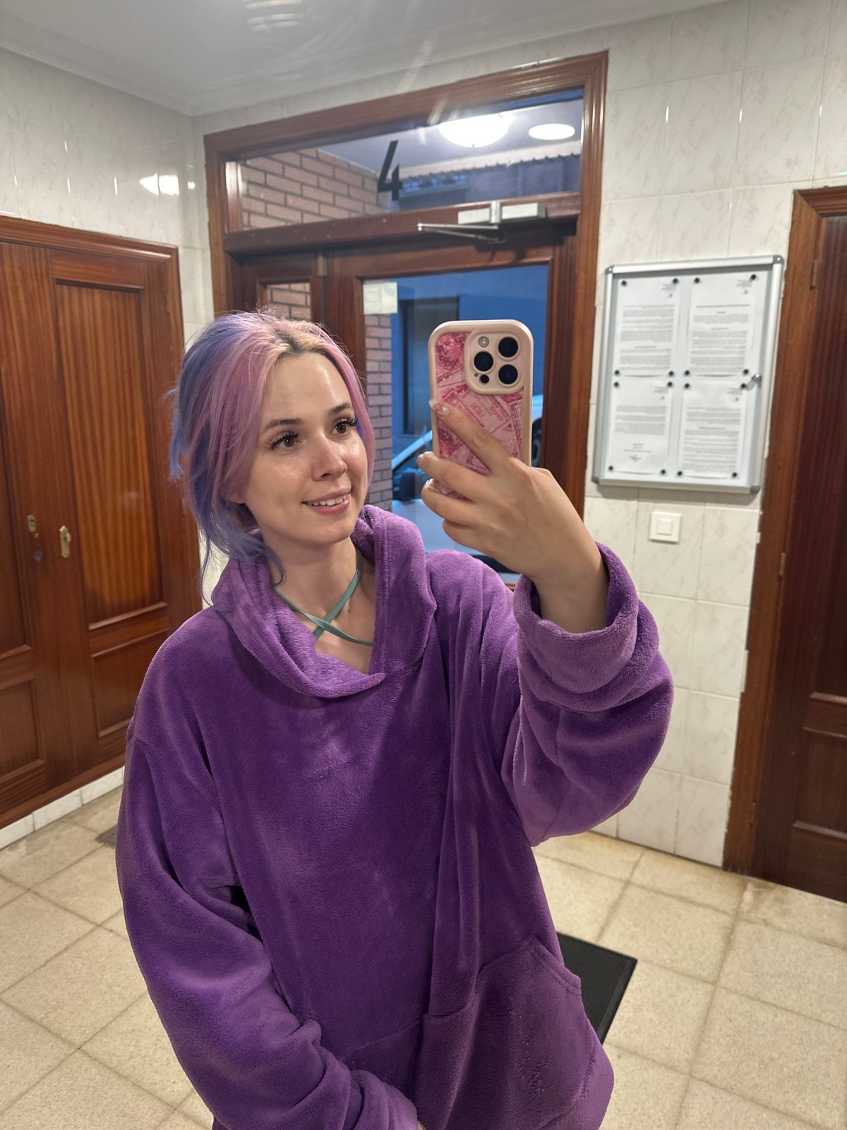 Woman takes selfie with pink phone in Gijón