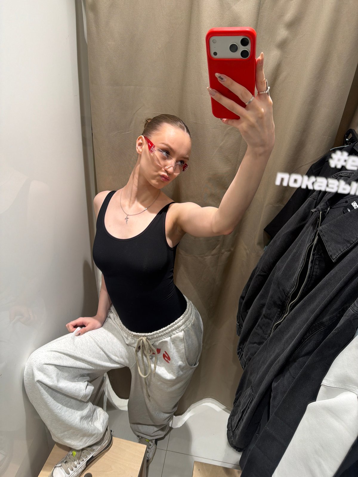 Woman takes selfie in clothing store fitting room