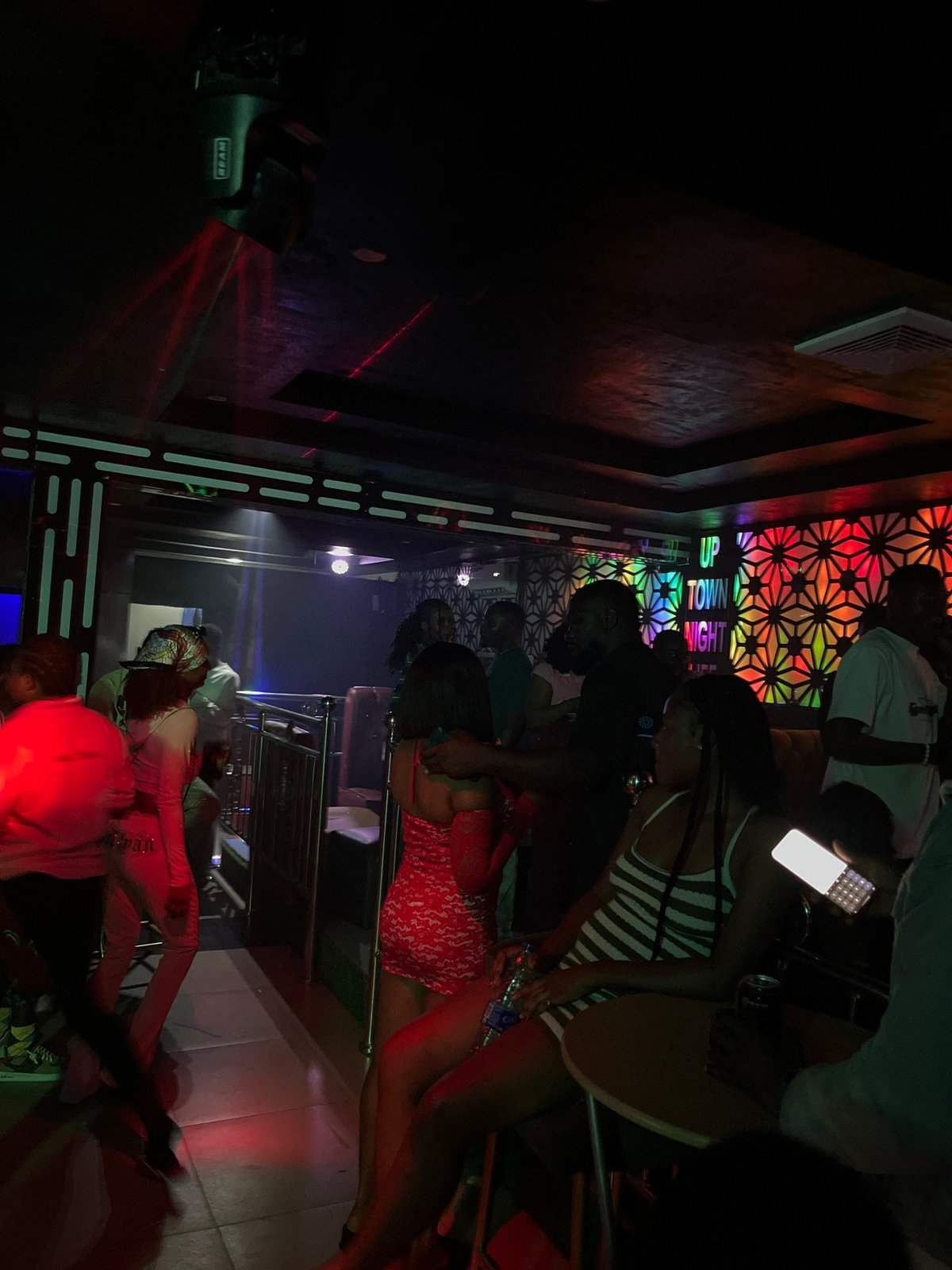 Late-night club scene with dancing and colored lights