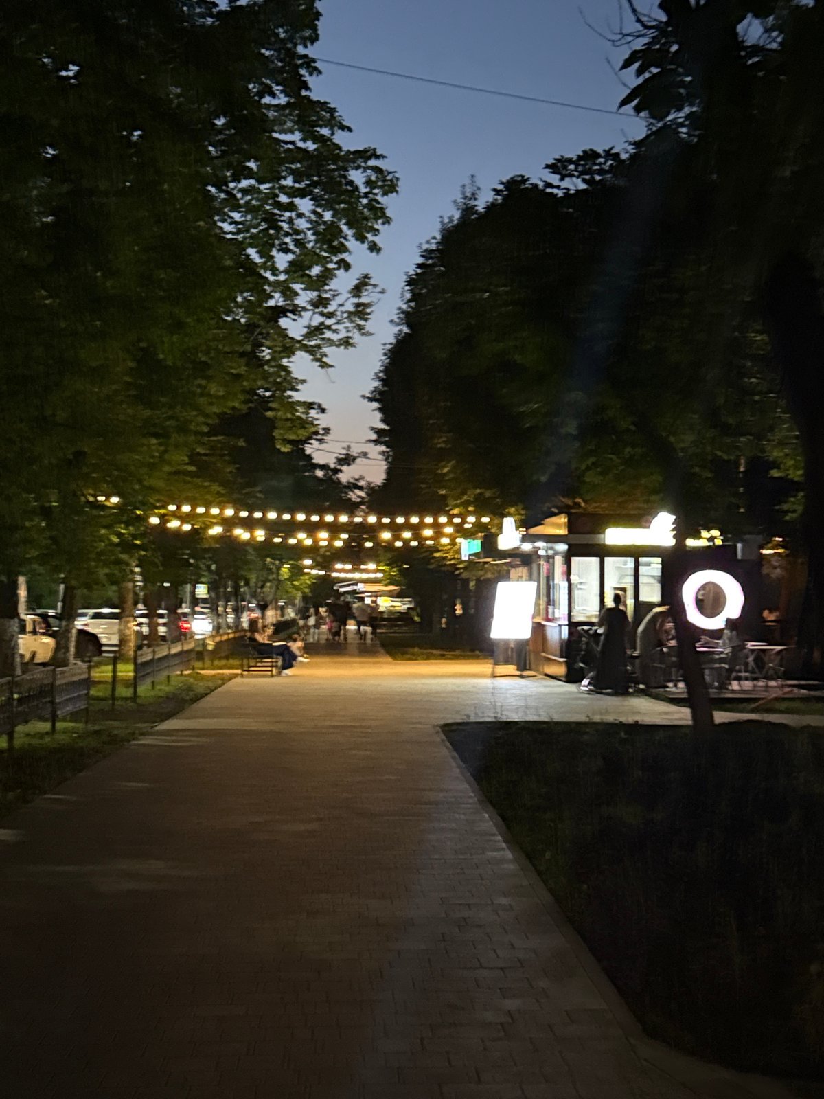 Nighttime stroll along a lit walkway in Khasavyurt
