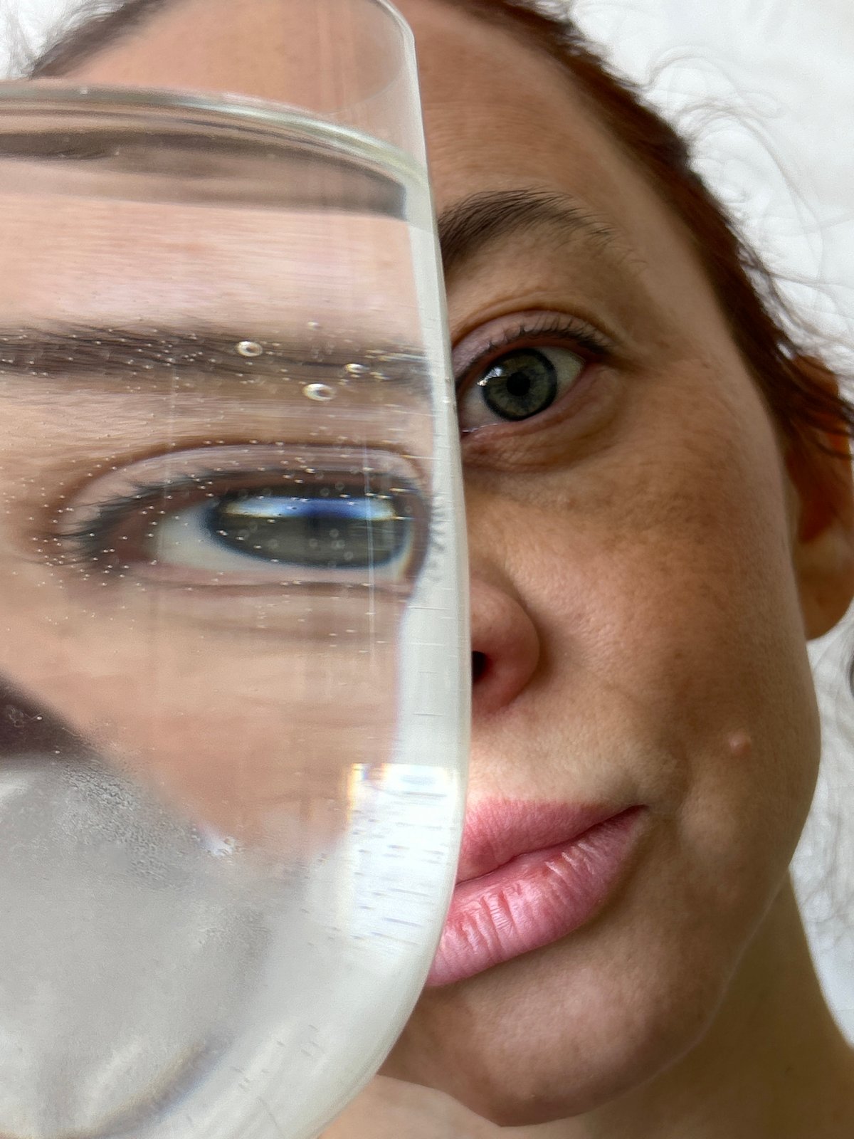 Person photographed through water glasses in Chaikovsky, Russia