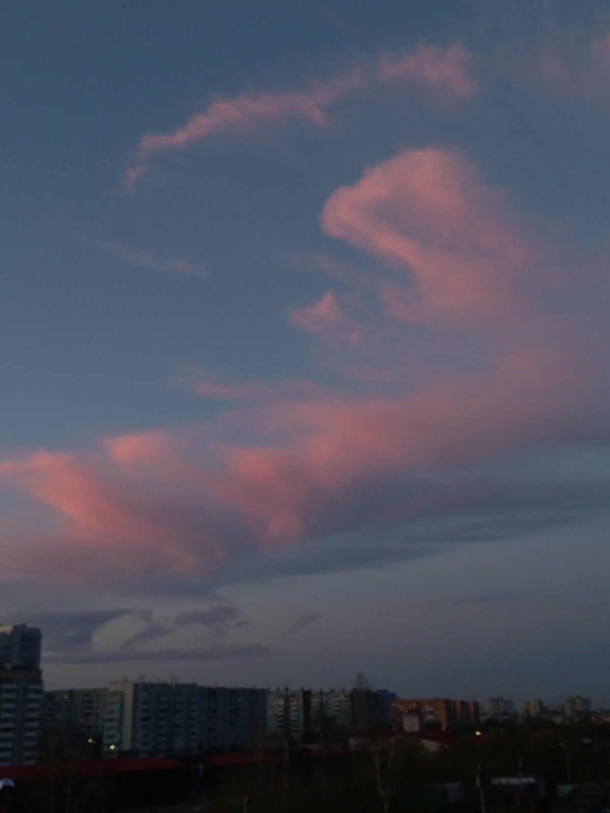 Dusk cityscape captured in Krasnoyarsk showing pink clouds over apartments