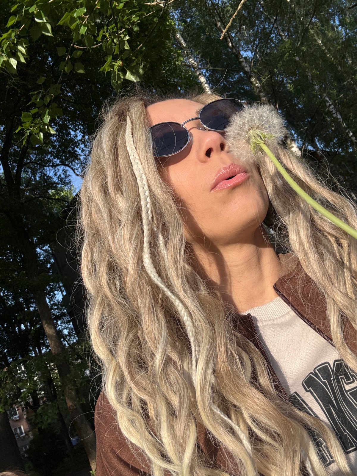 Woman poses with dandelions in sunny Russian countryside photoshoot