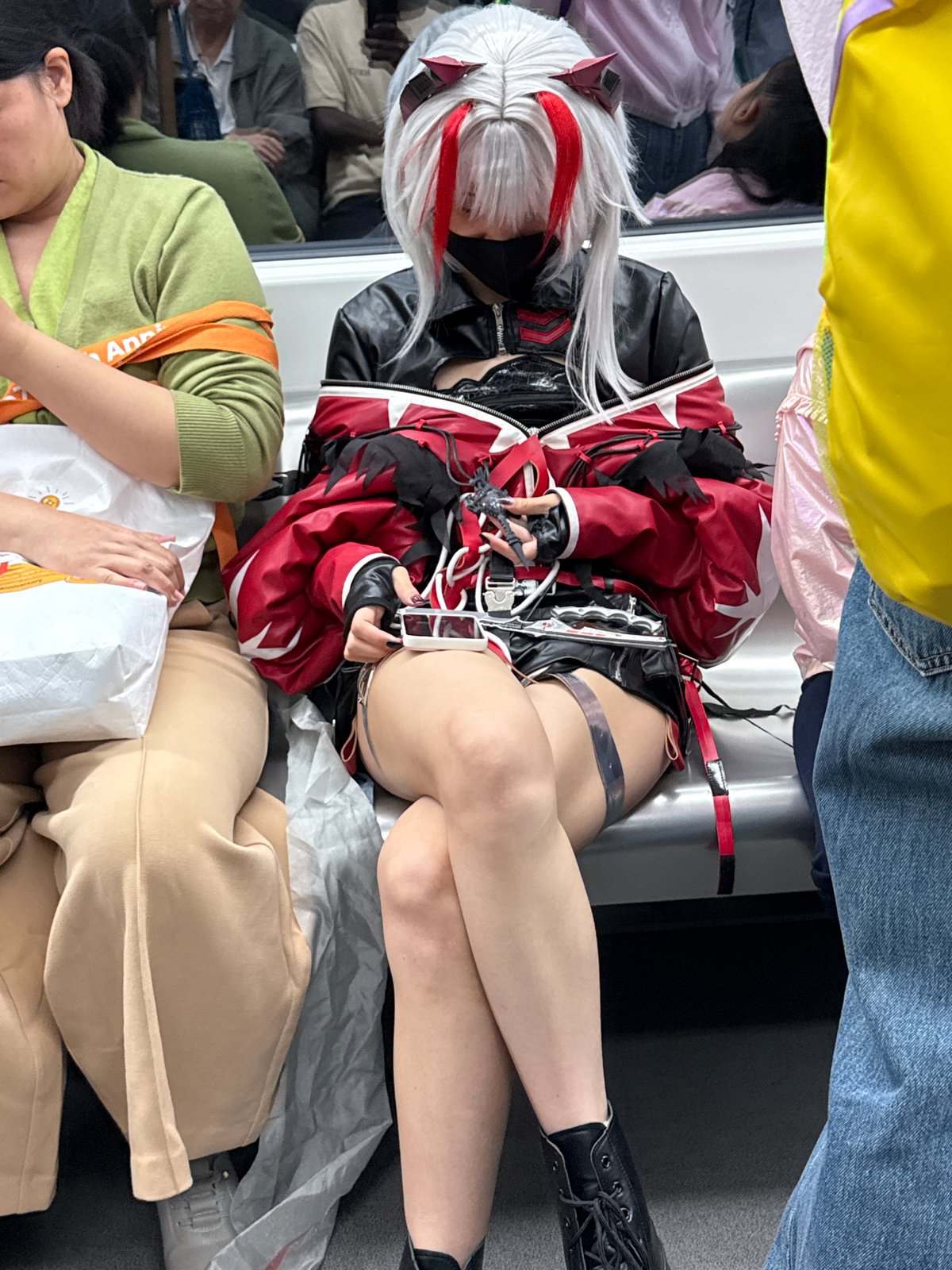 Cosplayer in red-black outfit documented at indoor gathering