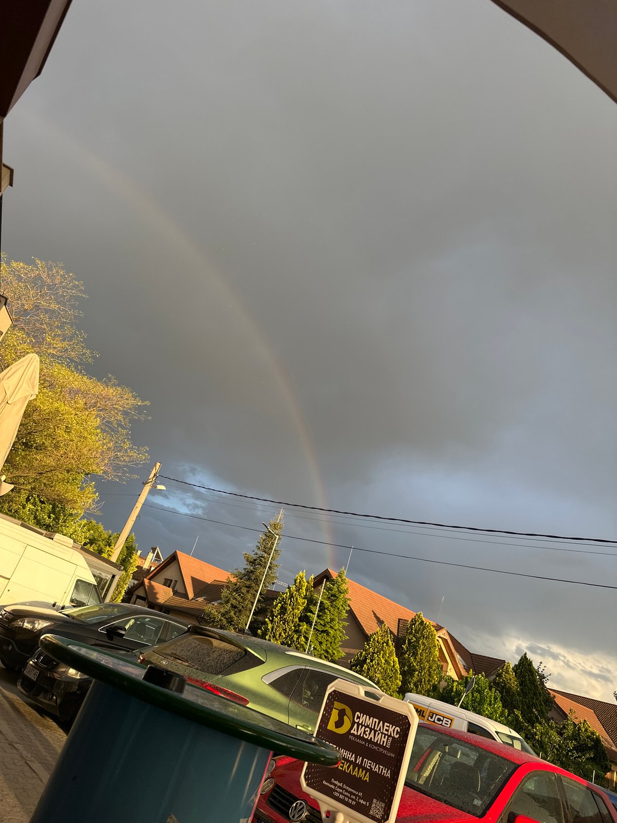 Rainbow appears over Plovdiv streets on overcast afternoon