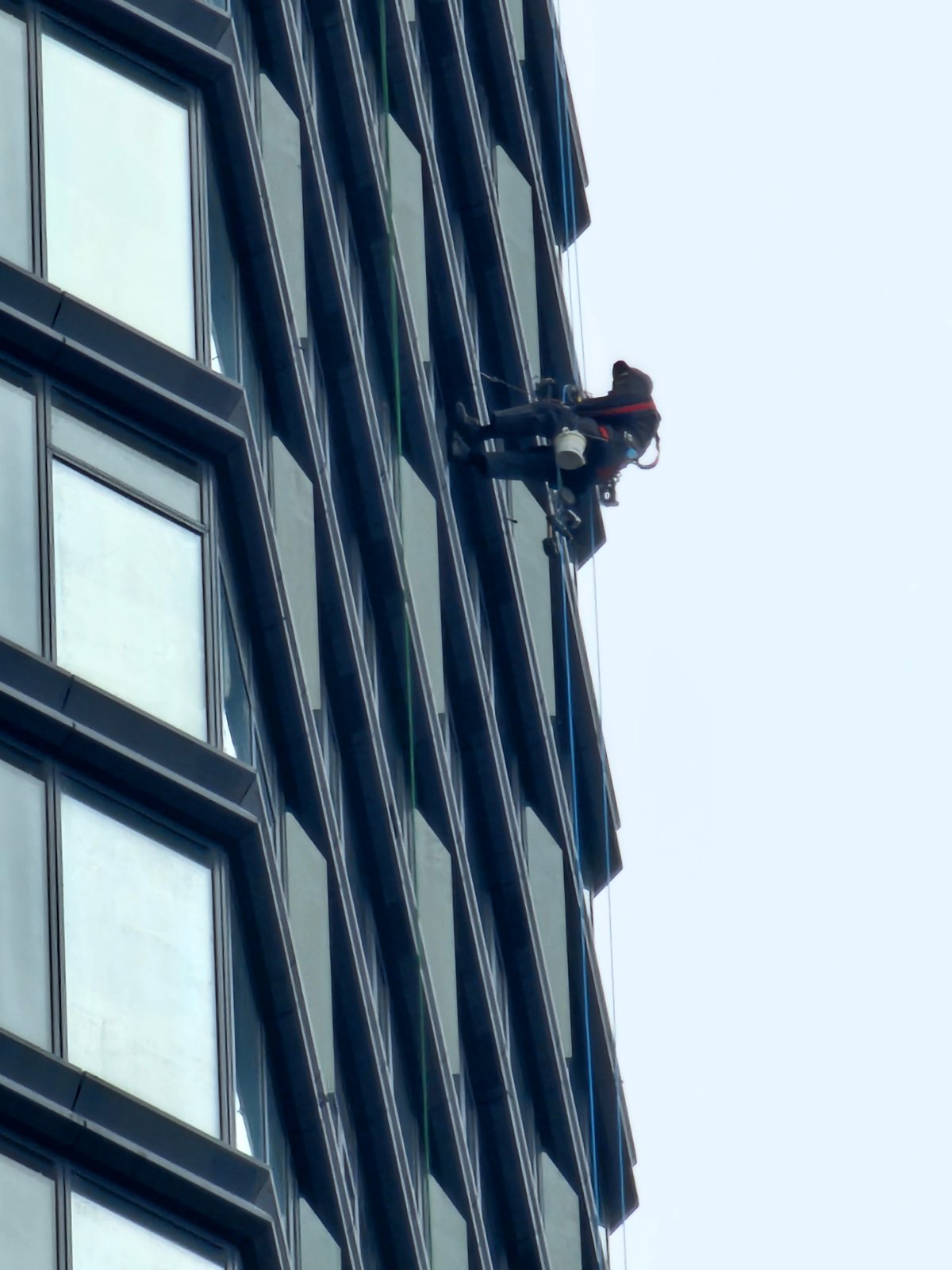 Workers rappel down Moscow building during maintenance operations