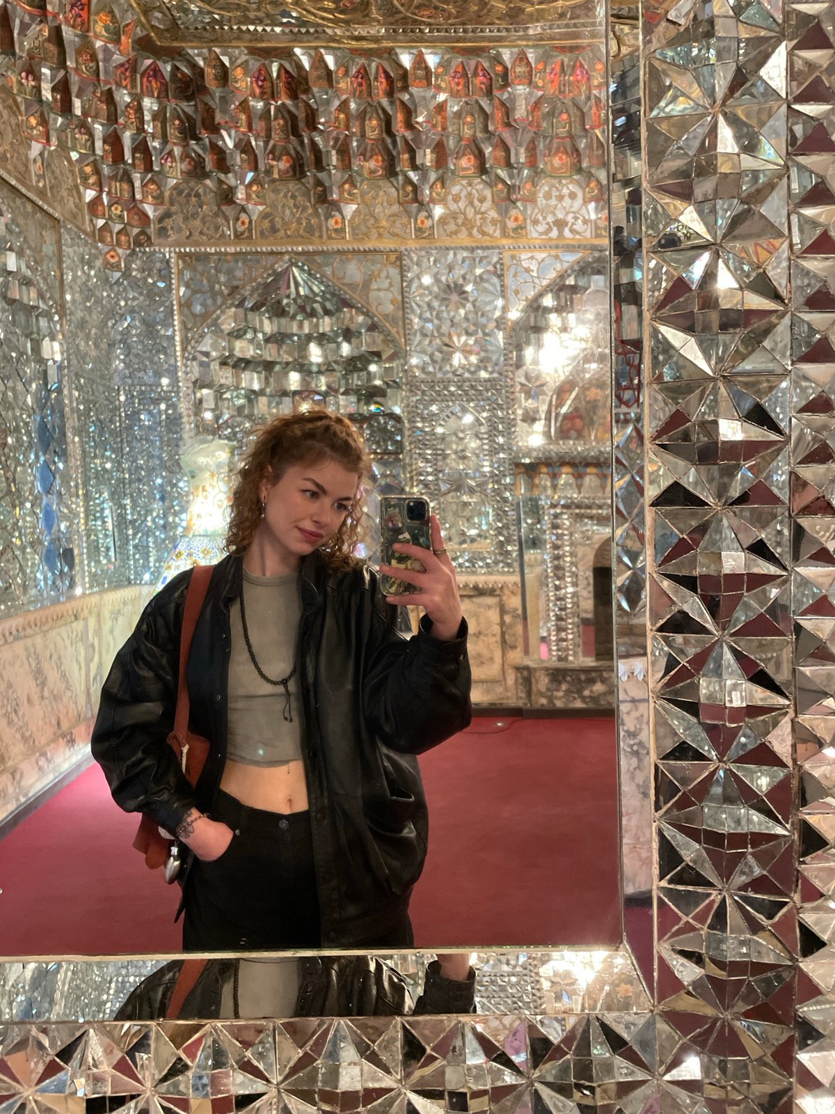 Woman takes mirror selfie in ornate kaleidoscopic room, Tbilisi