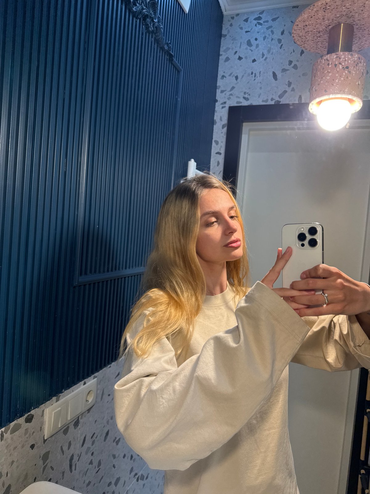 Woman takes bathroom selfies with white smartphone Friday evening
