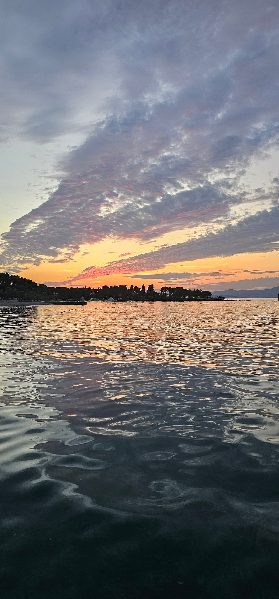 Supetar waterfront at golden hour: ferries, painters, and promenade life
