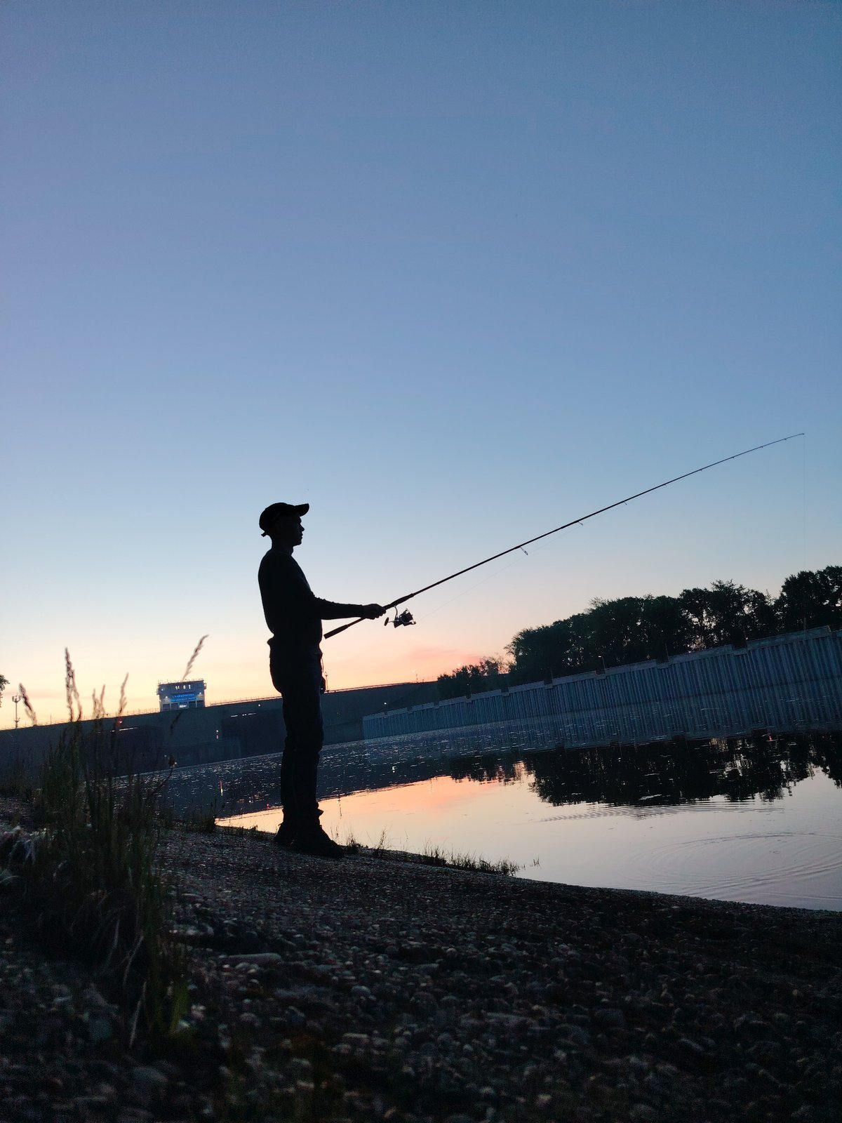 Evening fishing observed near Chaikovsky dam at dusk