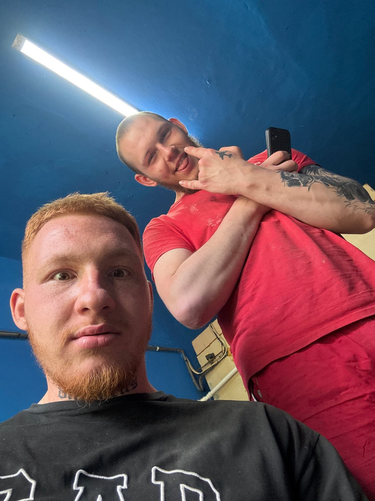 Two men take selfies indoors in Makiivka, Ukraine